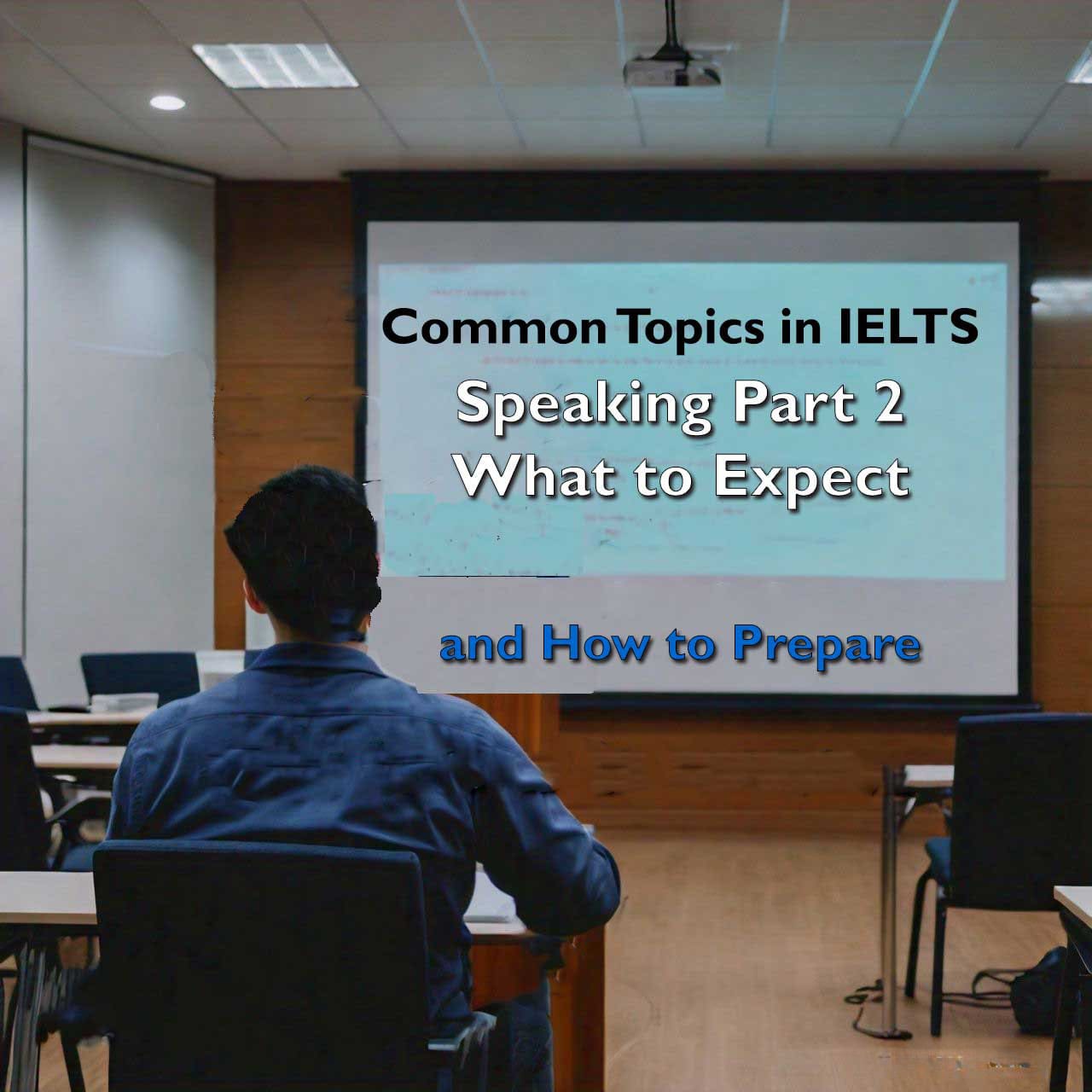 Person in a blue shirt sitting in a conference room facing a presentation screen with text ‘Common Topics in IELTS Speaking Part 2 What to Expect and How to Prepare’.